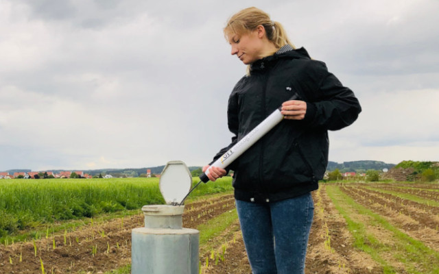 hydrologist deploying a groundwater level device into a well