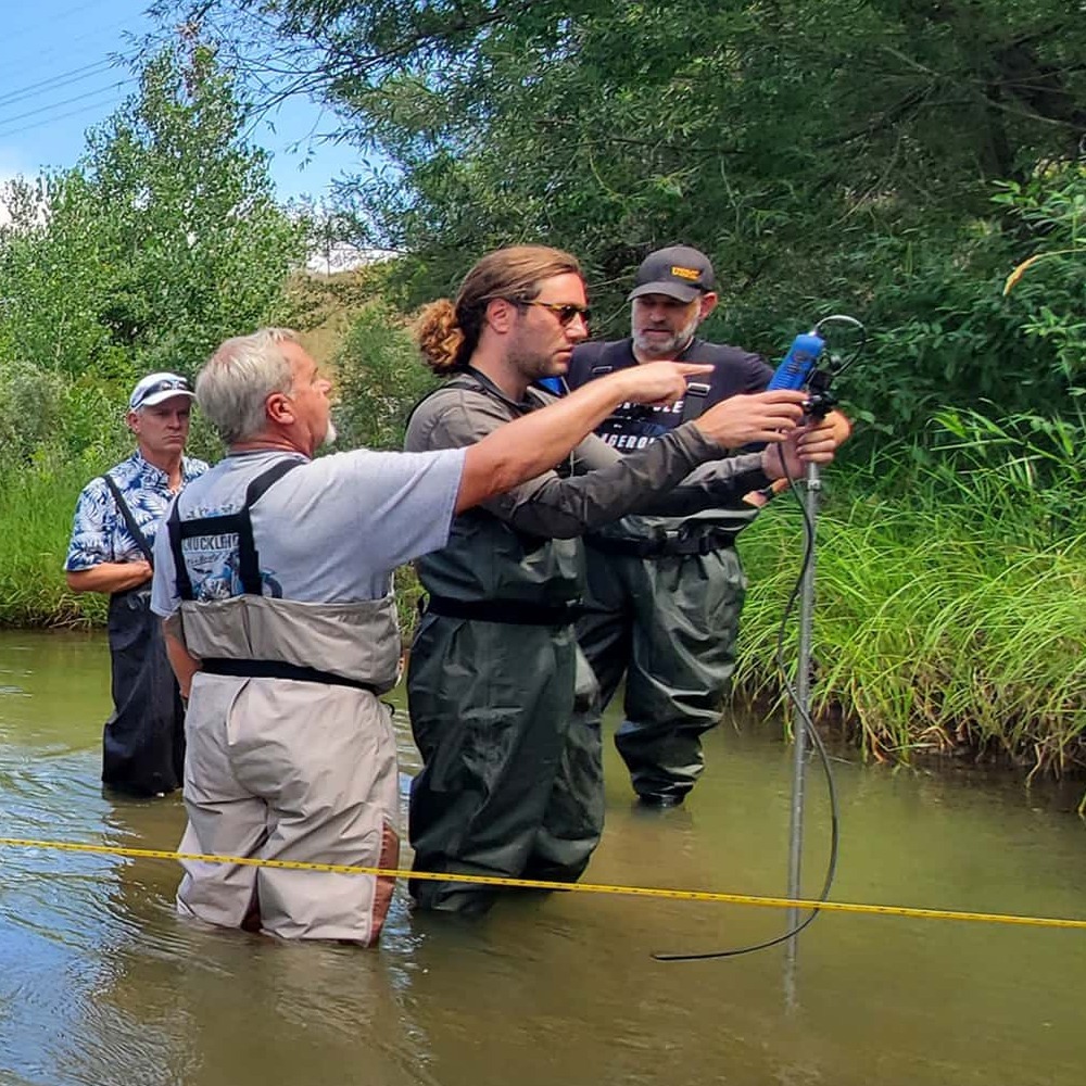 Hydrologist collecting velocity and depth readings for discharge calculations in river