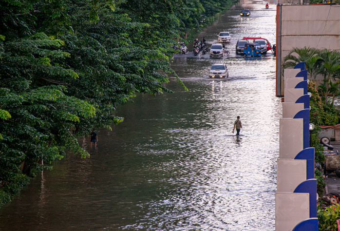 man wading through flood waters in a city